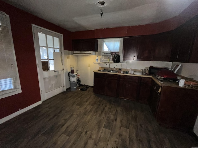 kitchen with dark wood-type flooring, a sink, light countertops, and plenty of natural light