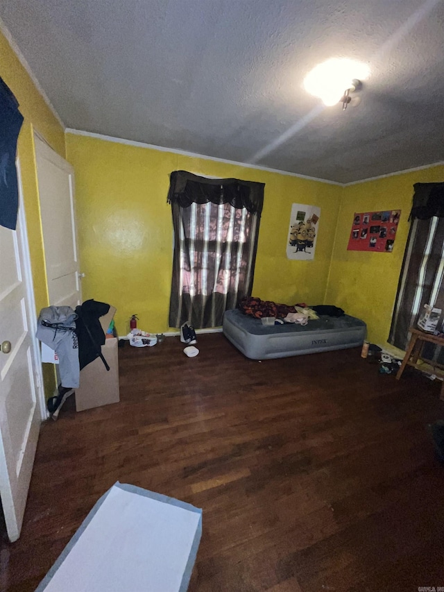 bedroom with wood finished floors and a textured ceiling