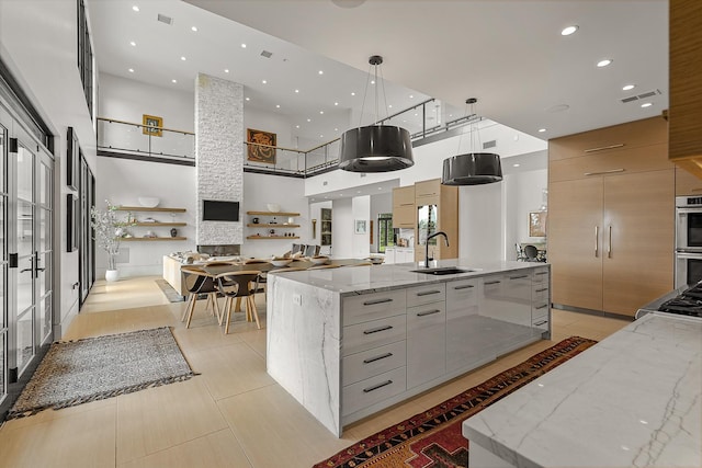 3307 Pruetts Chapel Rd, Paragould, AR 72450 - kitchen featuring modern cabinets, a sink, a large island with sink, a towering ceiling, and open floor plan