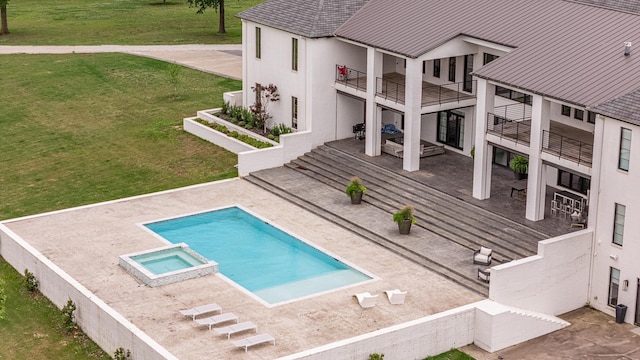 3307 Pruetts Chapel Rd, Paragould, AR 72450 - rear view of property featuring a balcony, stucco siding, a yard, a pool with connected hot tub, and a patio
