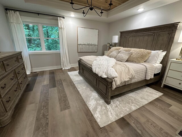 2529 Brandy Dr, Heber Springs, AR 72543 - bedroom featuring dark wood-type flooring, baseboards, a chandelier, and a tray ceiling