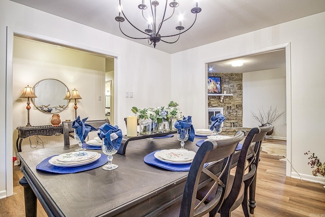 30 Segovia Dr, Hot Springs Village, AR 71909 - dining area with light wood finished floors, baseboards, a chandelier, and a fireplace