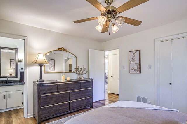 30 Segovia Dr, Hot Springs Village, AR 71909 - bedroom with a sink, wood finished floors, connected bathroom, a ceiling fan, and a closet