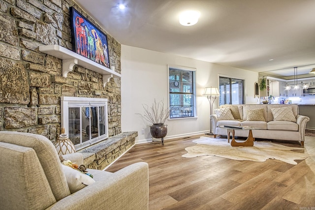30 Segovia Dr, Hot Springs Village, AR 71909 - living area featuring a stone fireplace, baseboards, and wood finished floors