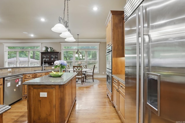 53 Maisons, Little Rock, AR 72223 - kitchen with stainless steel appliances, crown molding, a sink, a center island, and brown cabinets