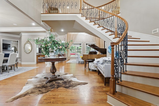 53 Maisons, Little Rock, AR 72223 - stairs featuring ornamental molding, wood finished floors, baseboards, a high ceiling, and recessed lighting