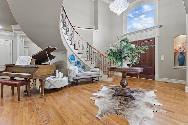 53 Maisons, Little Rock, AR 72223 - foyer featuring a towering ceiling, light wood-style floors, stairway, a chandelier, and baseboards