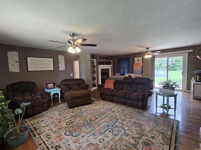 2373 W Rd, Mount Pleasant, AR 72561 - living area featuring a ceiling fan, wood finished floors, a textured ceiling, and a fireplace
