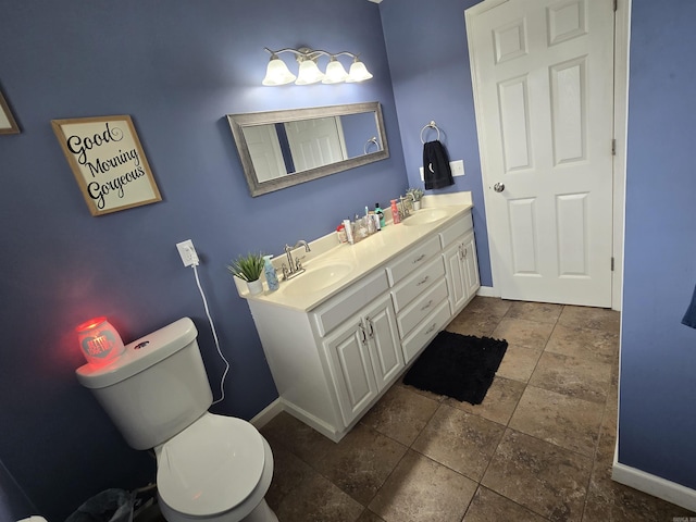 2373 W Rd, Mount Pleasant, AR 72561 - bathroom featuring baseboards, double vanity, stone tile flooring, and toilet