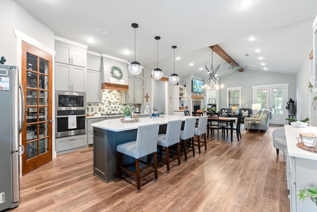 152 Clayboy Dr, Austin, AR 72007 - kitchen featuring stainless steel appliances, light countertops, light wood-style floors, a kitchen breakfast bar, and recessed lighting