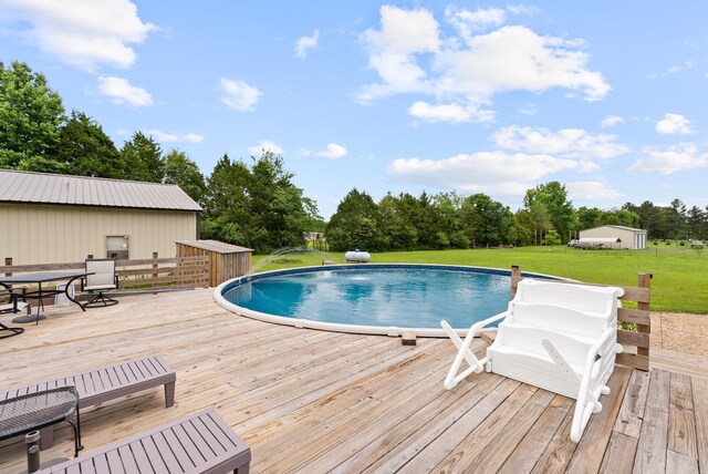 152 Clayboy Dr, Austin, AR 72007 - swimming pool featuring a wooden deck, a yard, and view of wooded area