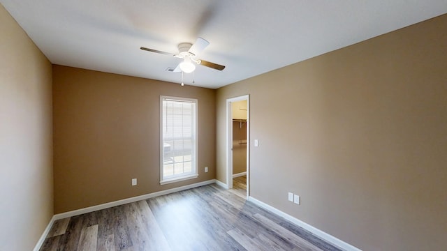 empty room with light wood-type flooring, ceiling fan, and baseboards