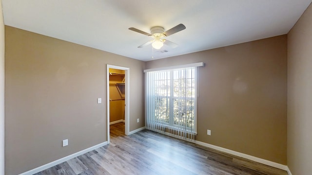 spare room with a ceiling fan, wood finished floors, and baseboards