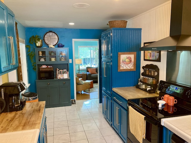 4613 Crestline Dr, North Little Rock, AR 72116 - kitchen with electric range, wall chimney exhaust hood, blue cabinetry, tile counters, and light tile patterned flooring
