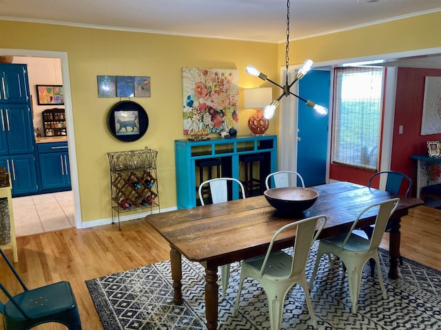 4613 Crestline Dr, North Little Rock, AR 72116 - dining room with a chandelier, light wood finished floors, ornamental molding, and baseboards
