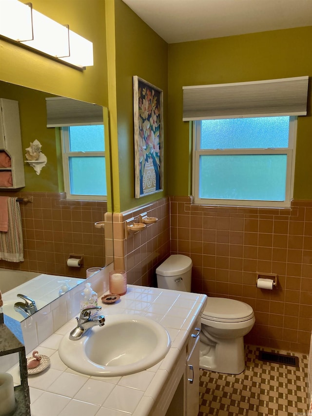 4613 Crestline Dr, North Little Rock, AR 72116 - bathroom with tile walls, wainscoting, vanity, and toilet