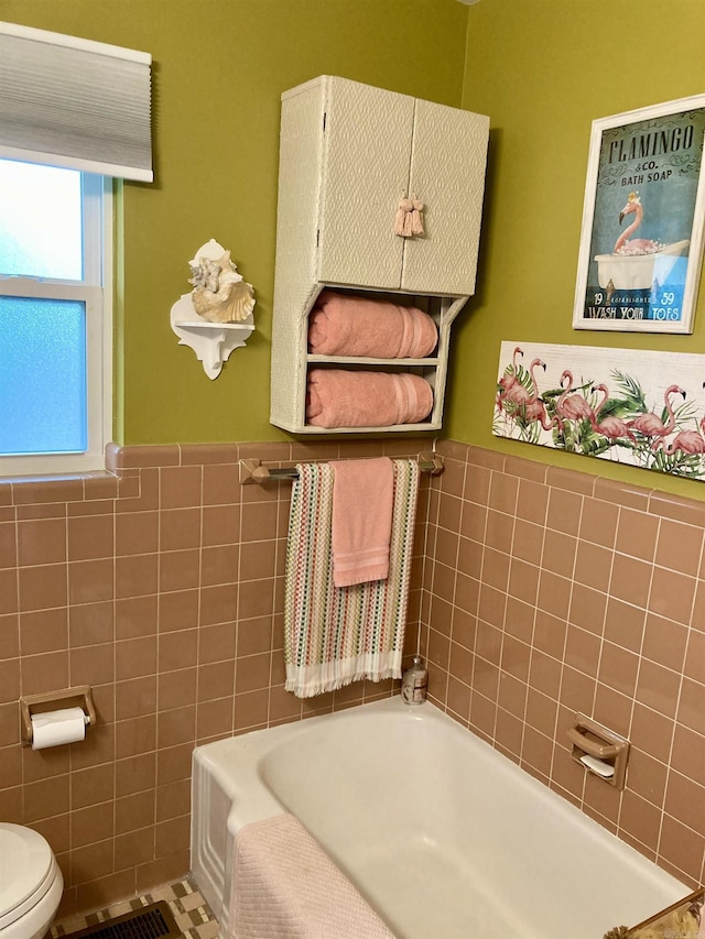 4613 Crestline Dr, North Little Rock, AR 72116 - bathroom featuring tile walls, a garden tub, toilet, and wainscoting