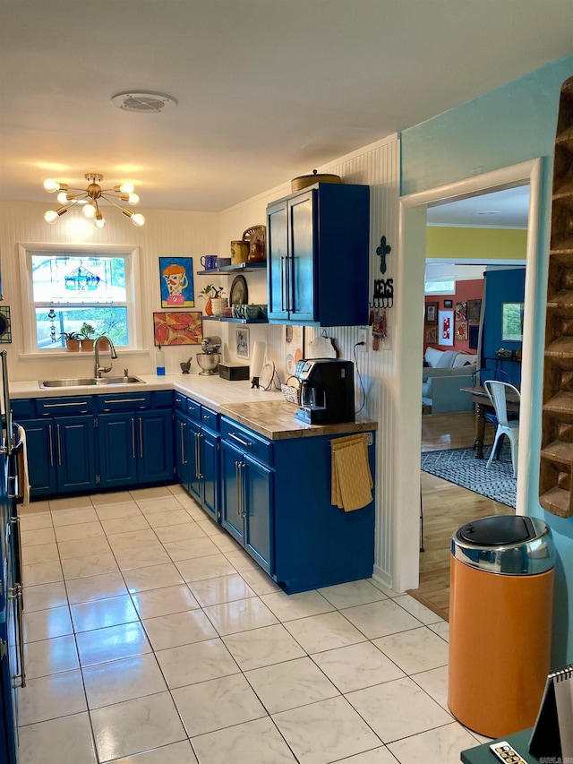 4613 Crestline Dr, North Little Rock, AR 72116 - kitchen featuring blue cabinets, a sink, open shelves, light countertops, and light tile patterned flooring
