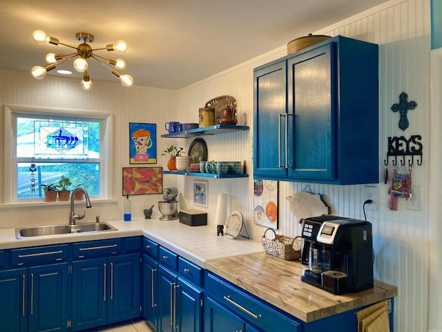 4613 Crestline Dr, North Little Rock, AR 72116 - kitchen with a sink, open shelves, blue cabinets, a chandelier, and ornamental molding