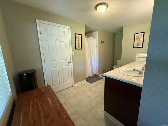 507 E Bruce St, Piggott, AR 72454 - bathroom with vanity, toilet, a shower with shower curtain, and baseboards