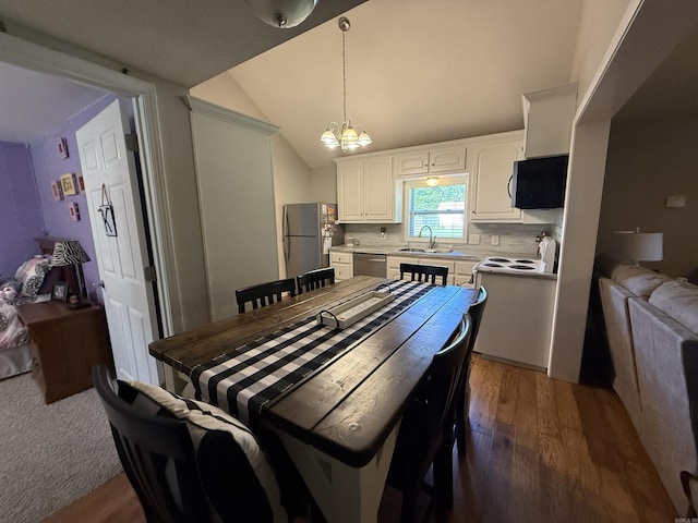 507 E Bruce St, Piggott, AR 72454 - dining area with a chandelier, wood finished floors, and lofted ceiling