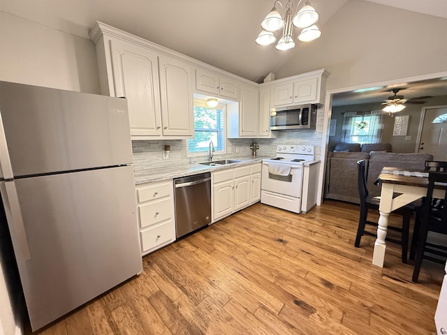 507 E Bruce St, Piggott, AR 72454 - kitchen with appliances with stainless steel finishes, a sink, light countertops, white cabinets, and vaulted ceiling