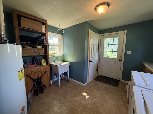 507 E Bruce St, Piggott, AR 72454 - laundry room featuring independent washer and dryer, water heater, cabinet space, a textured ceiling, and baseboards