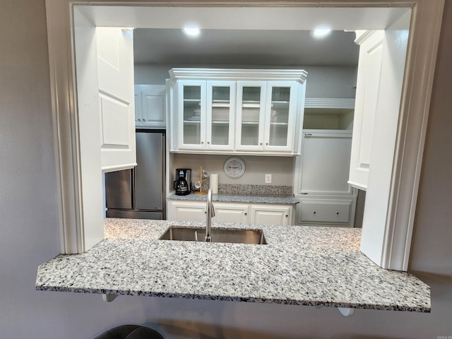 211 Burnt Rock Falls Rd, Fairfield Bay, AR 72088 - kitchen featuring high end refrigerator, a sink, glass insert cabinets, white cabinetry, and light stone counters