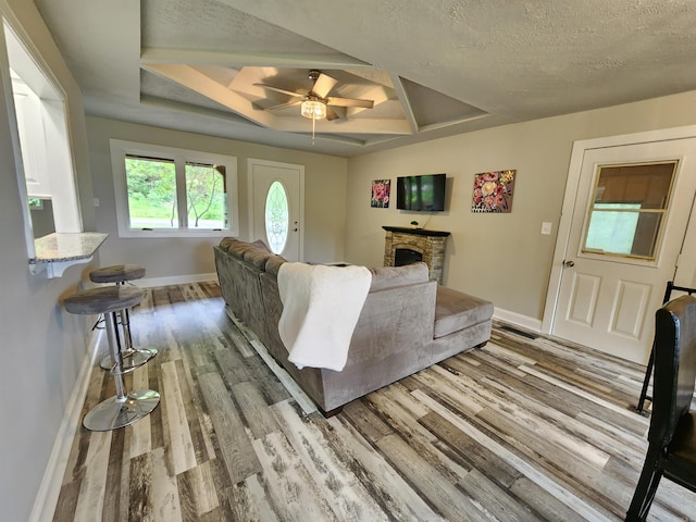 211 Burnt Rock Falls Rd, Fairfield Bay, AR 72088 - living room with coffered ceiling, wood finished floors, baseboards, ceiling fan, and a stone fireplace