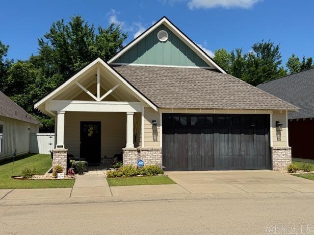 2880 Stonebrook Cv, Conway, AR 72034 - craftsman house featuring an attached garage, concrete driveway, roof with shingles, board and batten siding, and brick siding