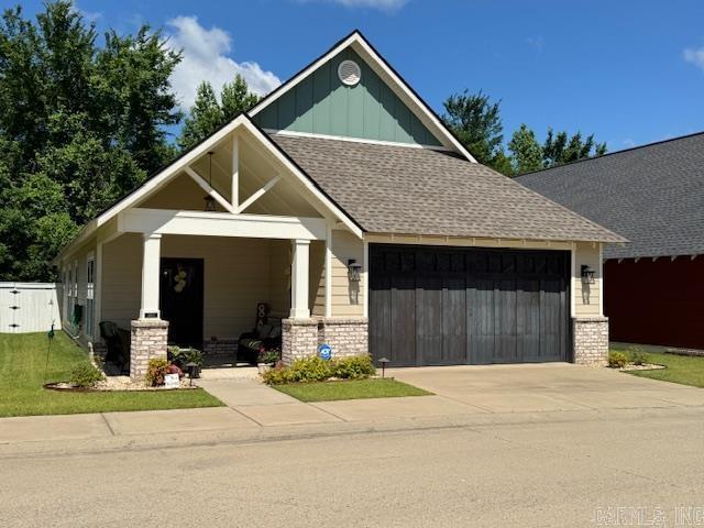 2880 Stonebrook Cv, Conway, AR 72034 - craftsman-style home with a garage, board and batten siding, concrete driveway, roof with shingles, and covered porch