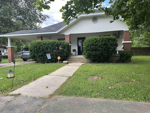 621 W 7th St, Rector, AR 72461 - view of front of house with a front lawn, brick siding, and an attached carport