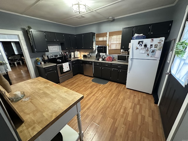 621 W 7th St, Rector, AR 72461 - kitchen featuring stainless steel appliances, dark cabinets, light wood finished floors, and ornamental molding