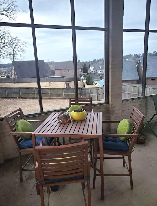 sunroom with outdoor dining area and a residential view