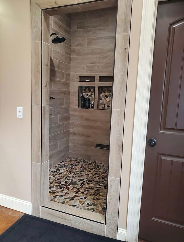 full bathroom featuring baseboards and a shower stall