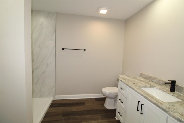 308 N Arch St, Sheridan, AR 72150 - bathroom with wood finished floors, toilet, a marble finish shower, vanity, and baseboards