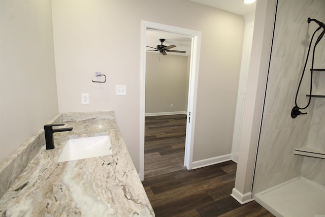 308 N Arch St, Sheridan, AR 72150 - bathroom featuring a tile shower, ceiling fan, wood finished floors, and double vanity