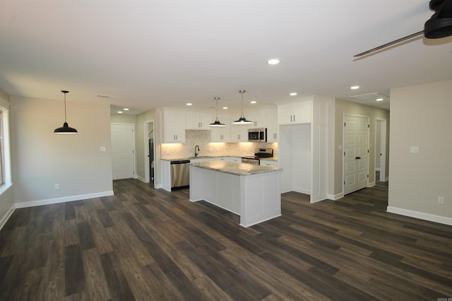 308 N Arch St, Sheridan, AR 72150 - kitchen with appliances with stainless steel finishes, recessed lighting, white cabinets, a center island, and baseboards