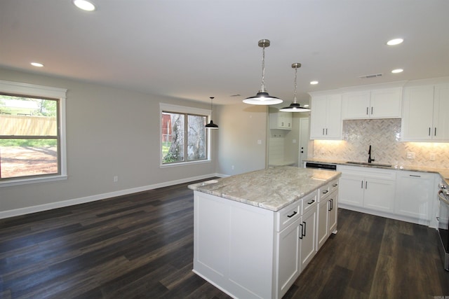 308 N Arch St, Sheridan, AR 72150 - kitchen featuring a sink, decorative backsplash, recessed lighting, light stone counters, and baseboards