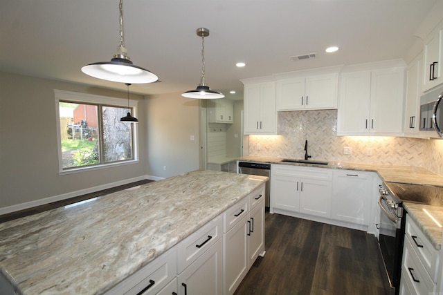 308 N Arch St, Sheridan, AR 72150 - kitchen featuring a sink, stainless steel appliances, dark wood-style floors, backsplash, and light stone counters