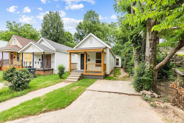 2506 W 6th St, Little Rock, AR 72205 - shotgun-style home with covered porch, a front lawn, and a shingled roof