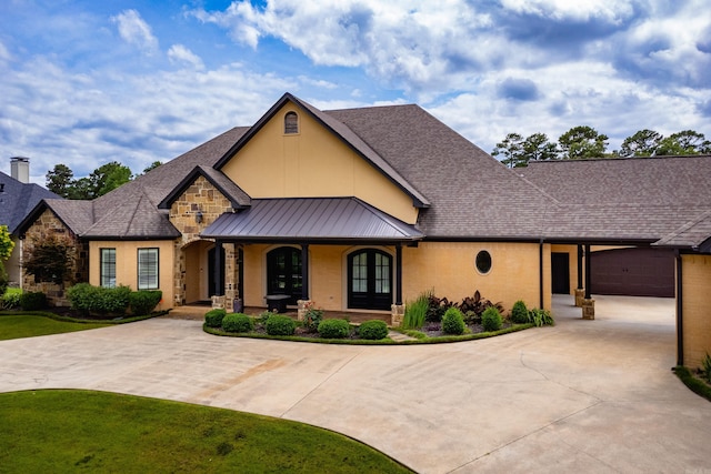 20 Accadia Ct, Little Rock, AR 72223 - view of front facade with covered porch, curved driveway, stone siding, a standing seam roof, and metal roof