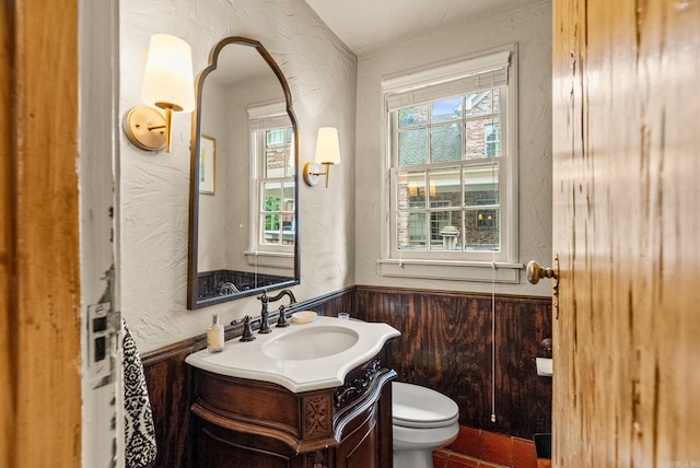1729 N Spruce, Little Rock, AR 72207 - bathroom with a textured wall, a wainscoted wall, vanity, toilet, and plenty of natural light