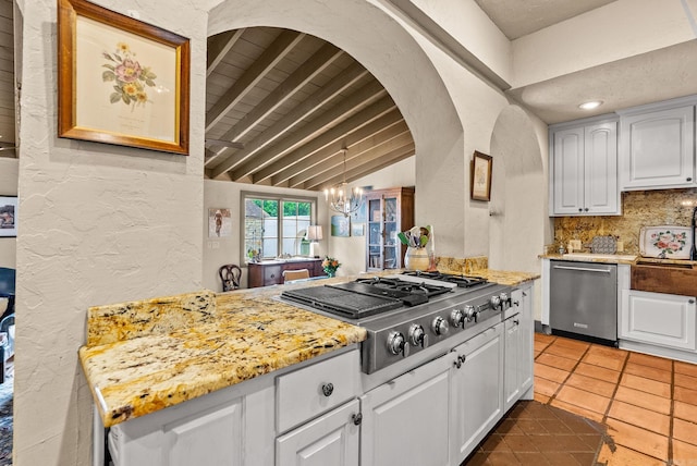 1729 N Spruce, Little Rock, AR 72207 - kitchen with appliances with stainless steel finishes, white cabinetry, a chandelier, decorative backsplash, and tile patterned floors