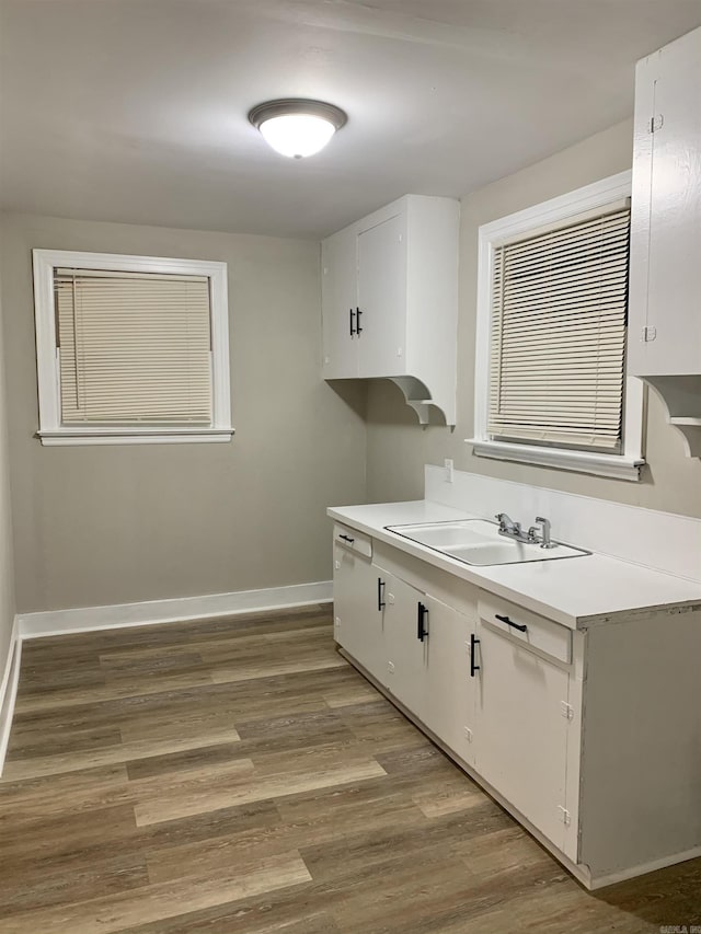 kitchen featuring a sink, light countertops, and baseboards