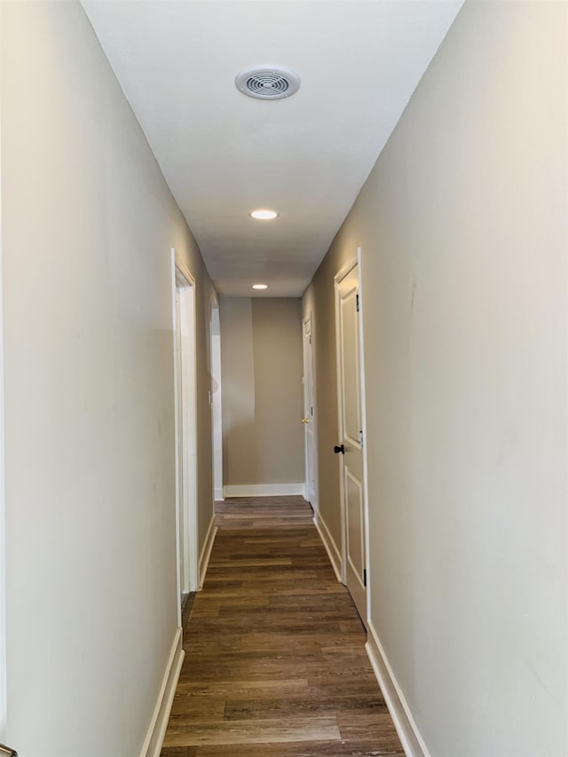 hall with dark wood-style flooring, baseboards, and recessed lighting