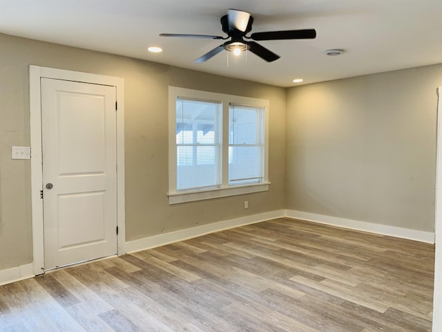 empty room with a ceiling fan, wood finished floors, baseboards, and recessed lighting