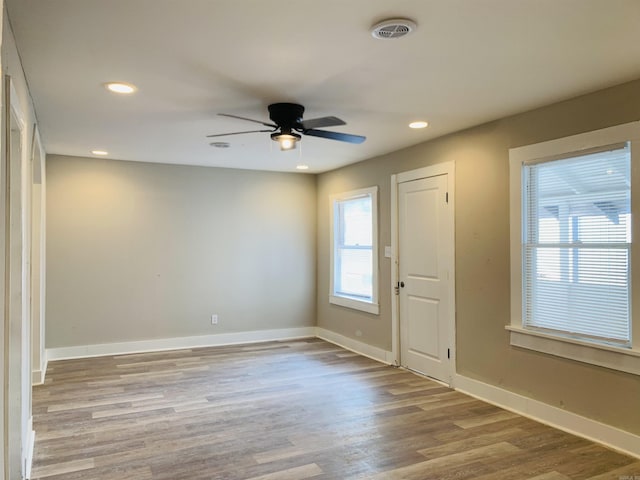 empty room featuring a ceiling fan, wood finished floors, baseboards, and recessed lighting