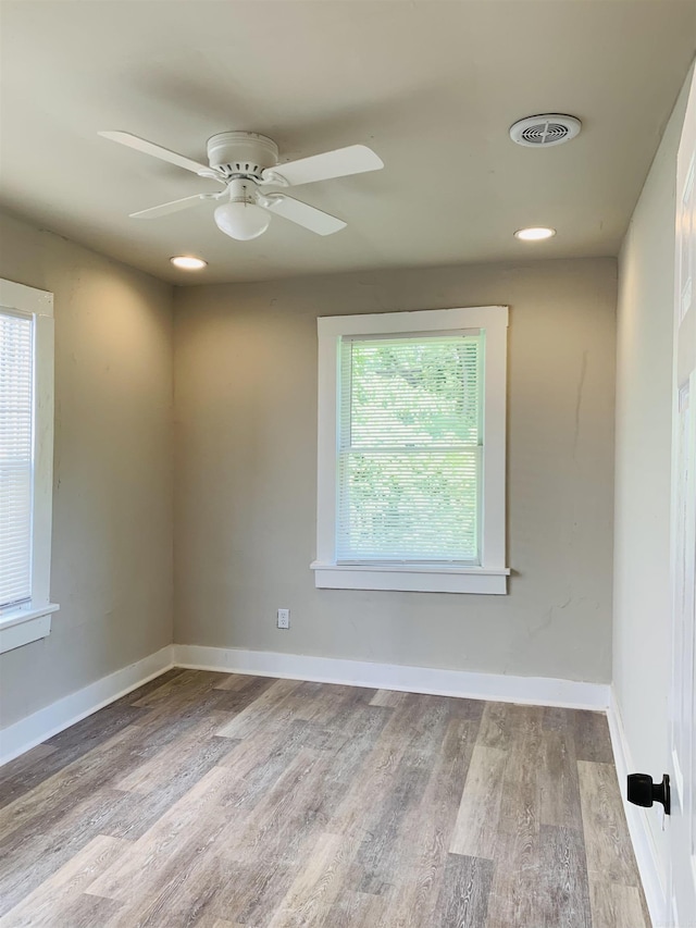 unfurnished room featuring plenty of natural light, wood finished floors, a ceiling fan, baseboards, and recessed lighting