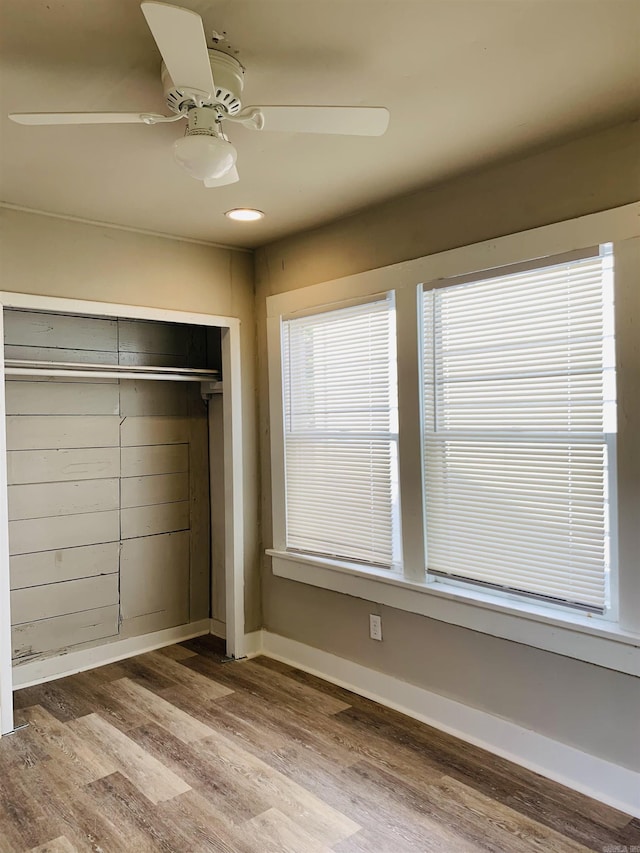 unfurnished bedroom featuring wood finished floors, a closet, a ceiling fan, baseboards, and recessed lighting